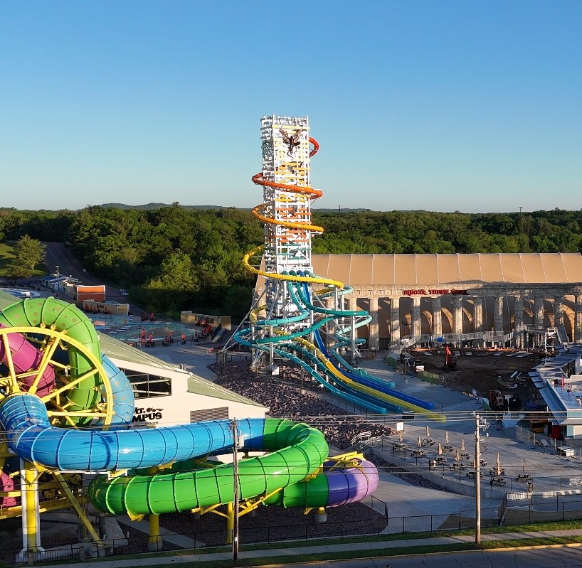 A very tall water slide tower at a water park with a SlideWheel at the foreground