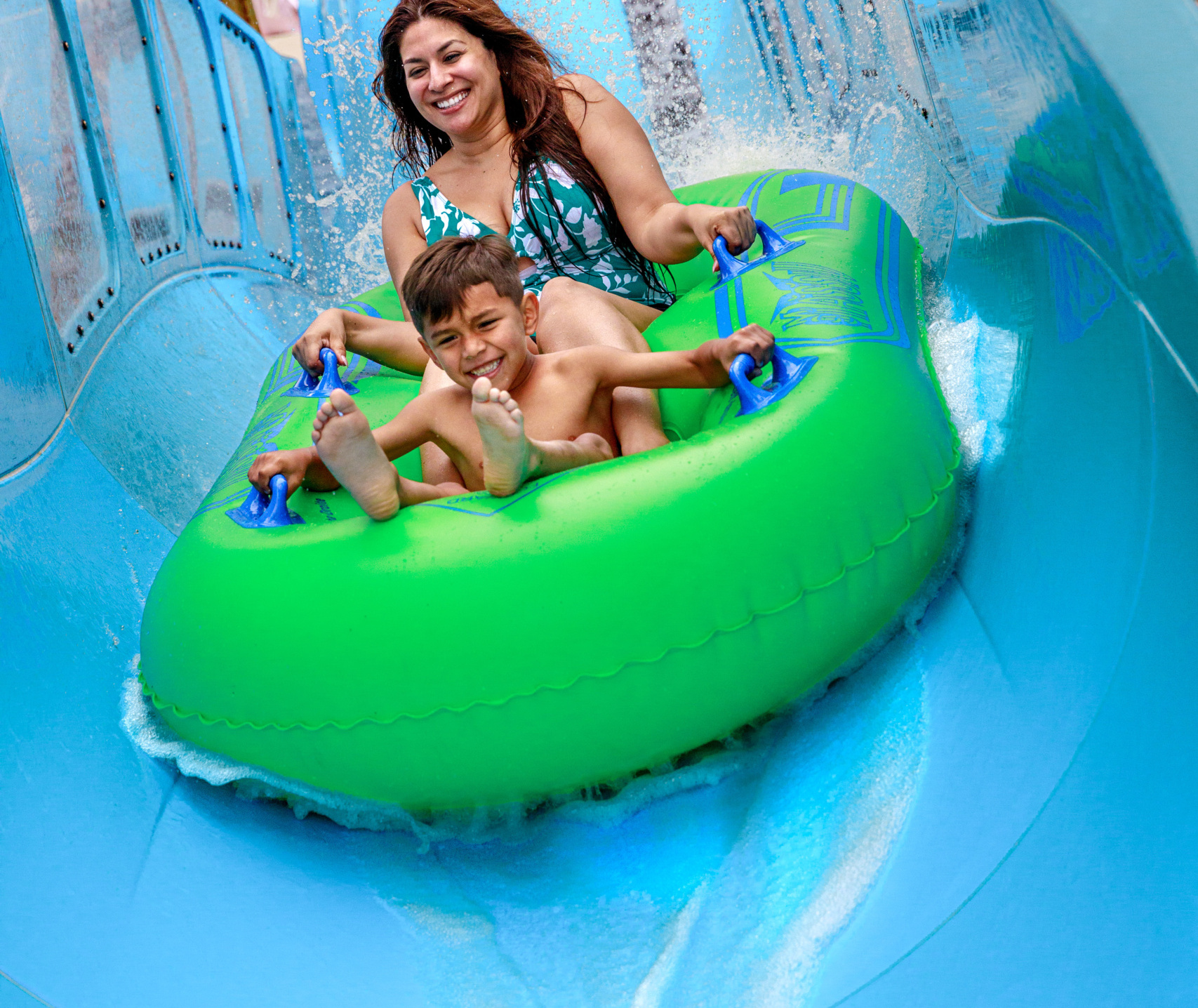 Small child and an adult in an inner tube on a water coaster