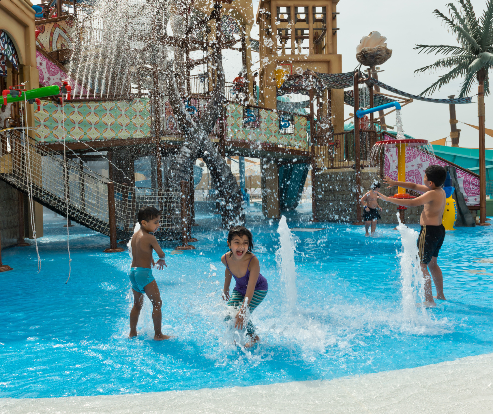 Kids playing under an aquatic play structure